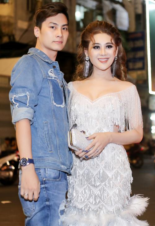 Chồng trẻ cúi người chỉnh váy cho Lâm Khánh Chi khi đi sự kiện